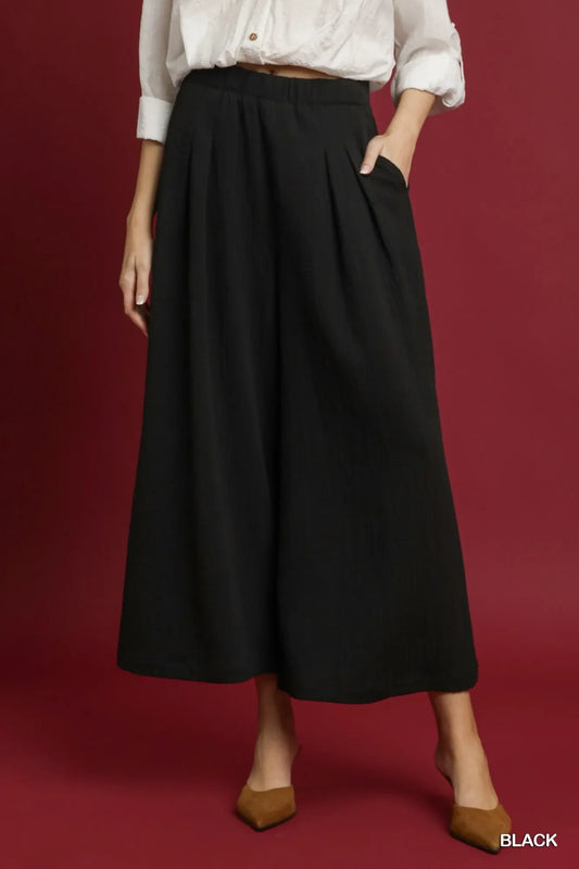 Black wide-leg pants with elastic waistband and gathered front pleats