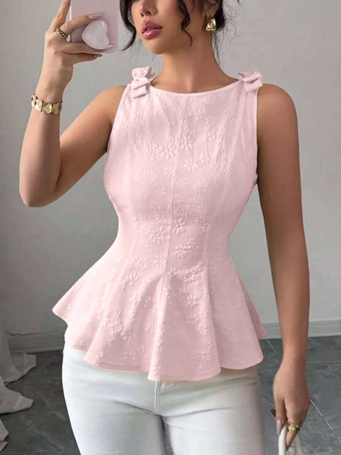 Pink bow-shoulder peplum tank with textured floral pattern and flared peplum hem