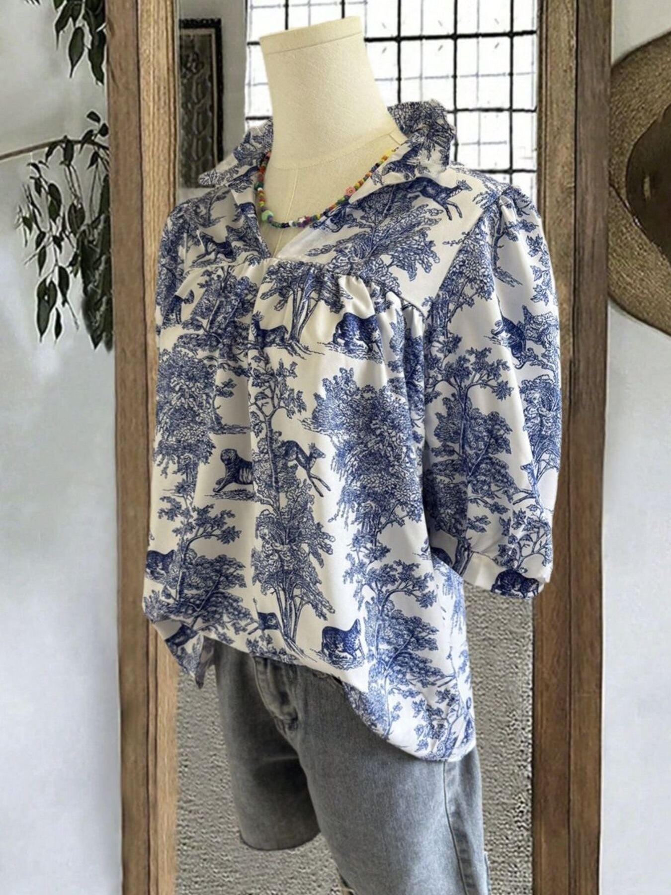 Front view of light indigo printed half-sleeve blouse with ruffled collar