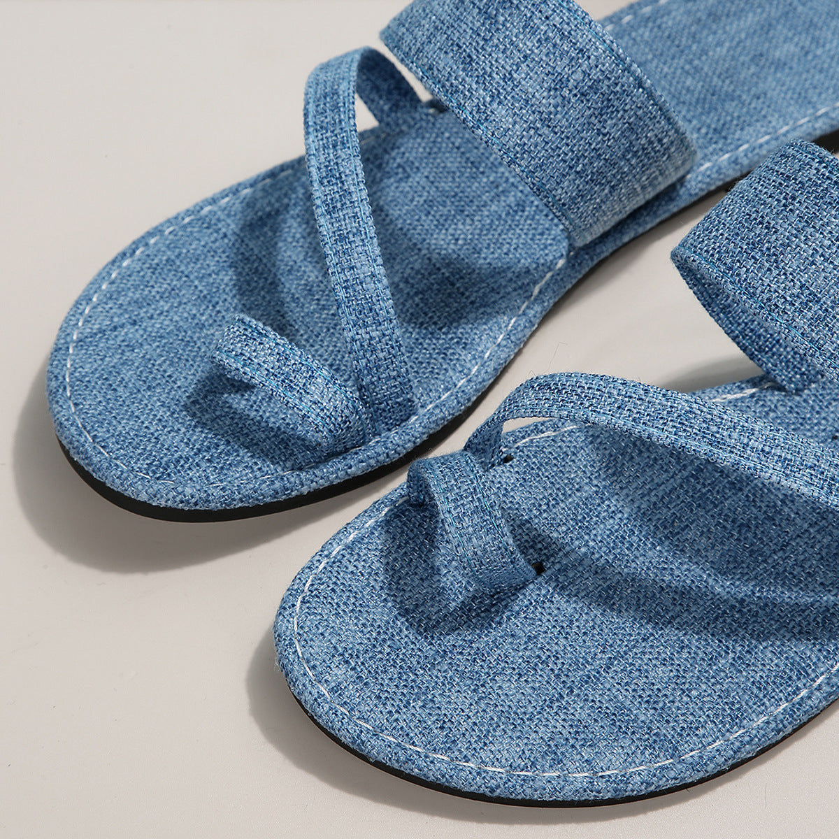Light blue toe loop sandals with thick cross straps and stitched sole