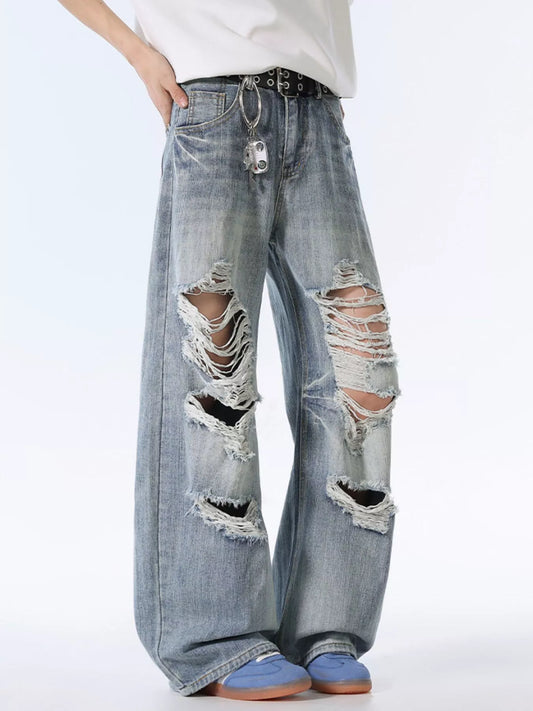 Blue distressed wide-leg jeans with heavy rips on front thighs and knees