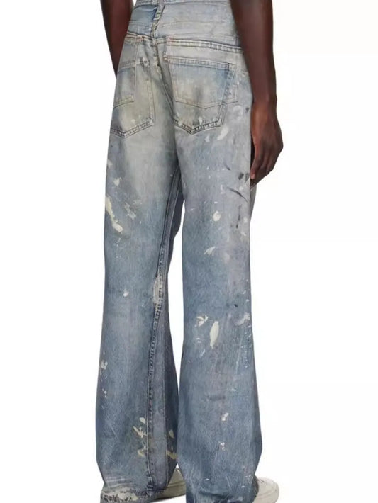 Medium wash straight jeans with rear pockets and wide leg, distressed paint spots
