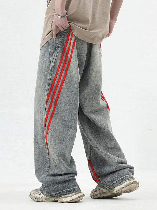 Men's wide-leg denim jeans in light wash with bold red striped side panel