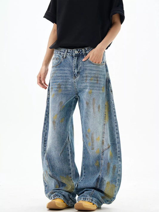 Blue wide-leg jeans with paint splatter, patch pockets, and relaxed straight-leg fit
