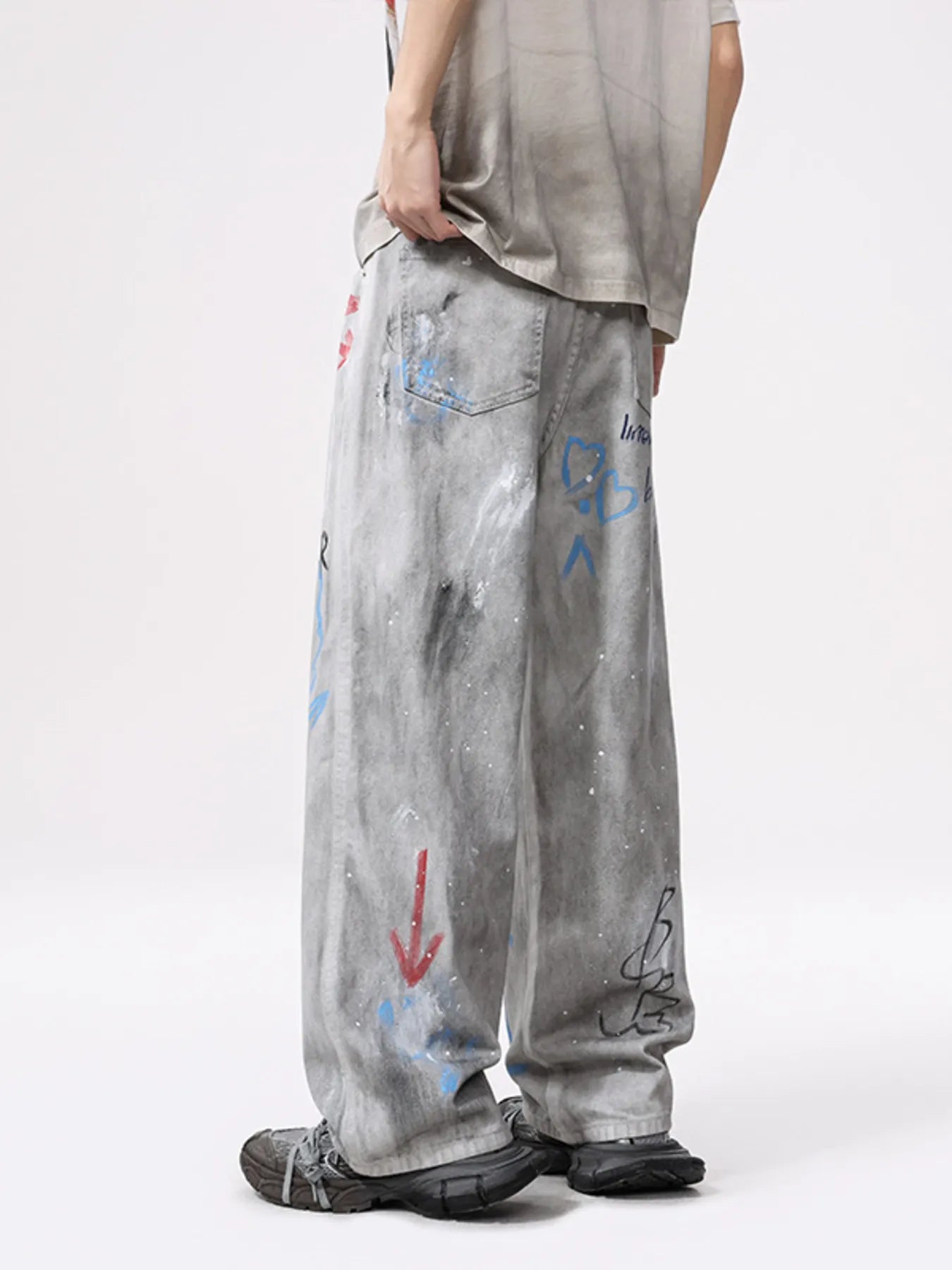 Light gray wide-leg jeans with distressing and scattered blue/red graffiti marks