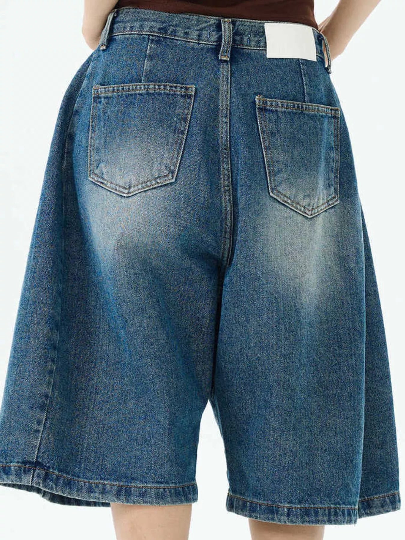 Blue wide-leg denim shorts with two back patch pockets and button waistband