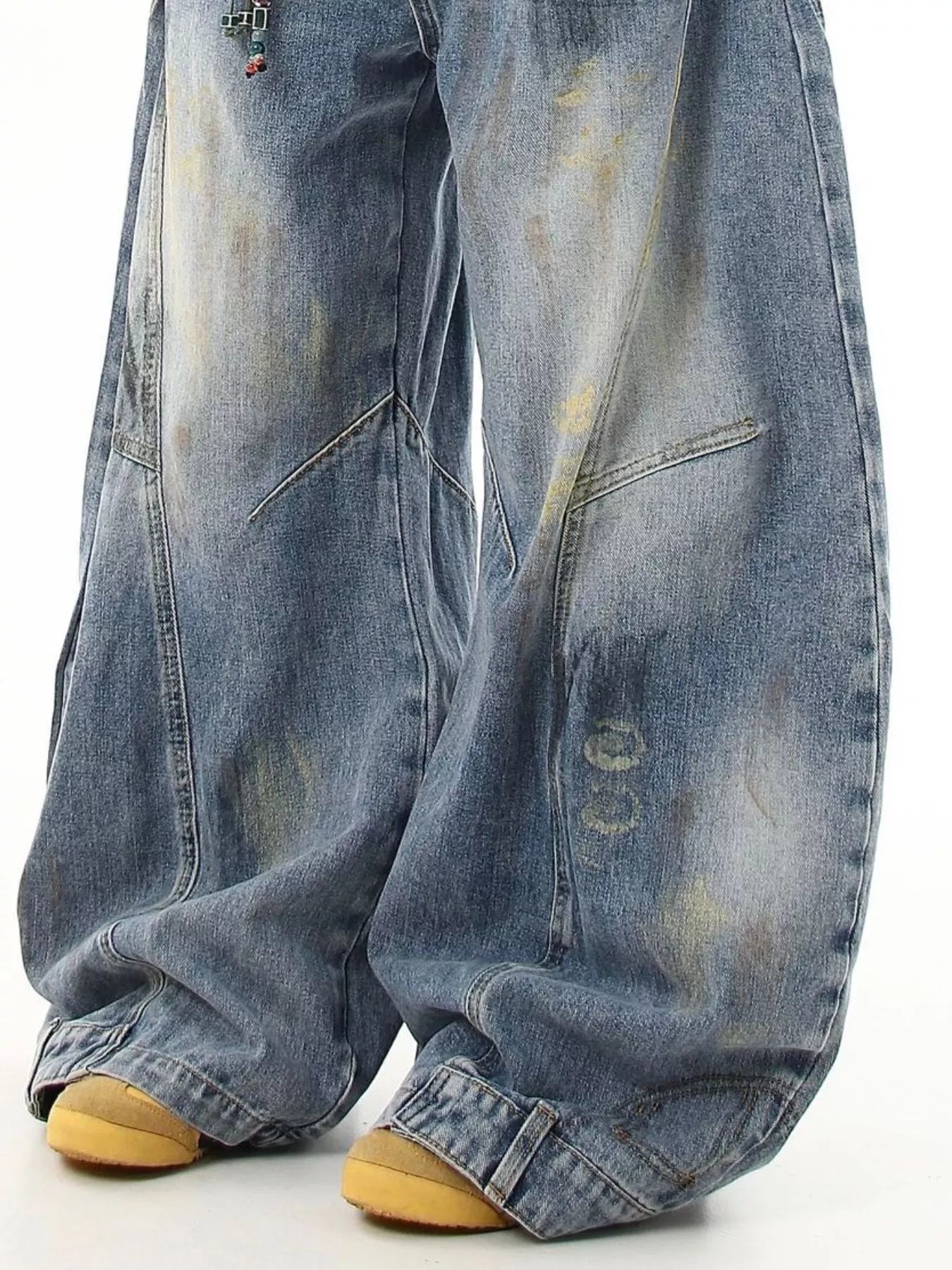 Blue wide-leg jeans showing relaxed knee and cuff detailing with worn wash