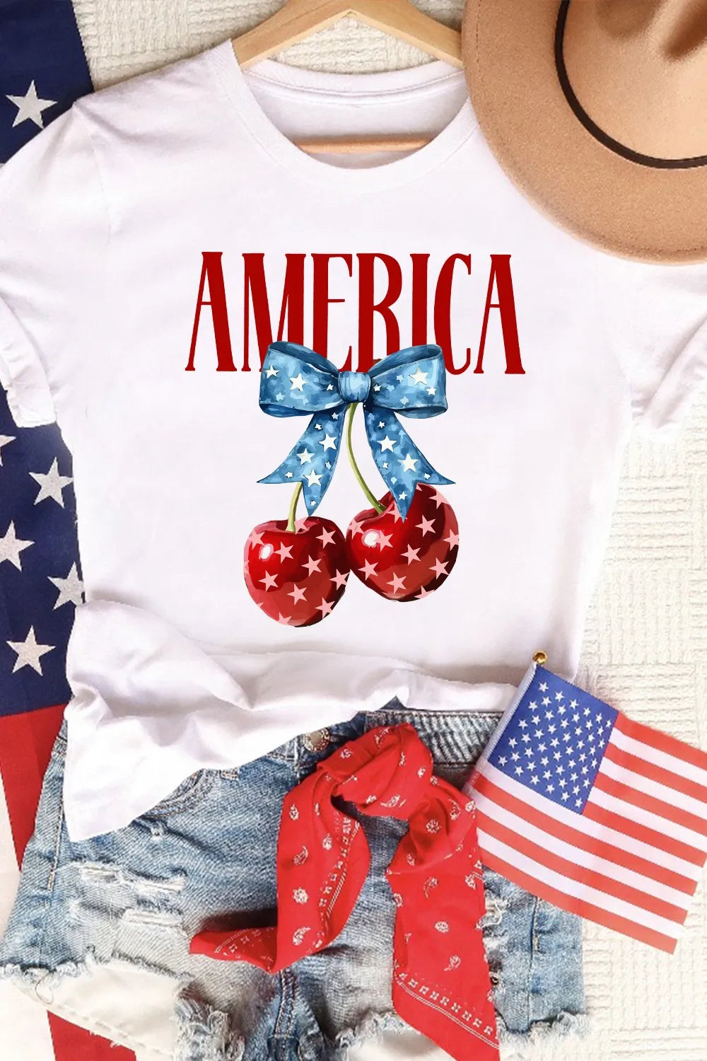 White crewneck T-shirt with AMERICA text and star-striped cherry graphic with bow