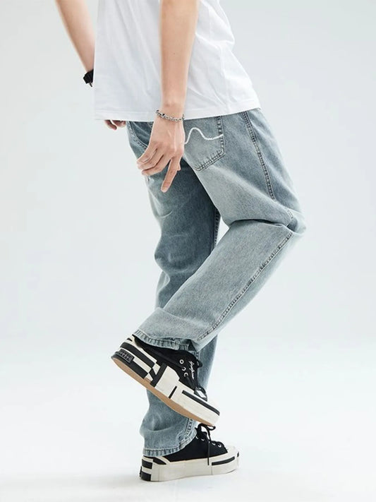 Light blue relaxed-fit jeans with cuffed hem and embroidered pocket seams.