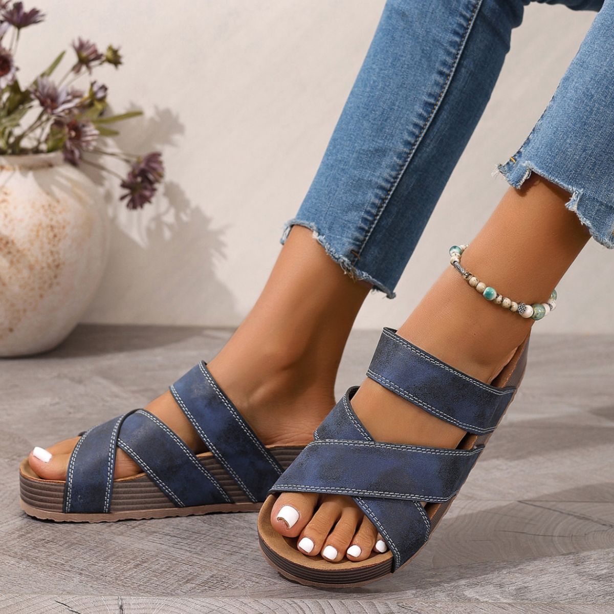 Blue open-toe platform sandals with wide cross straps and low platform wedge