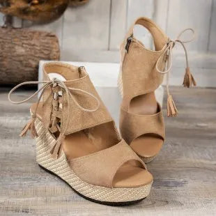 Tan peep-toe wedge sandals with lace-up ankle, tassel ties, and woven platform sole