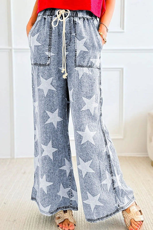 Washed blue wide-leg jeans with large star print and high-waist drawstring