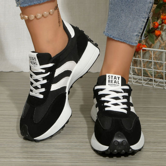 Black and white lace-up round-toe sneakers with white striped side panels