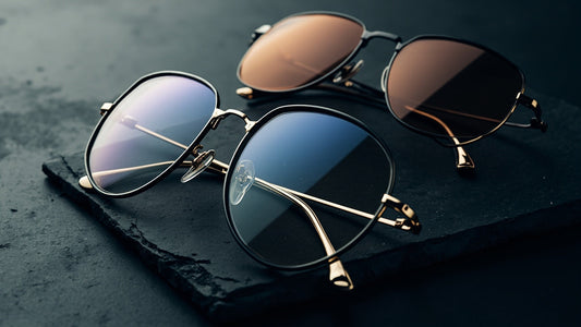 premium eyeglasses and sunglasses on dark stone with soft studio lighting