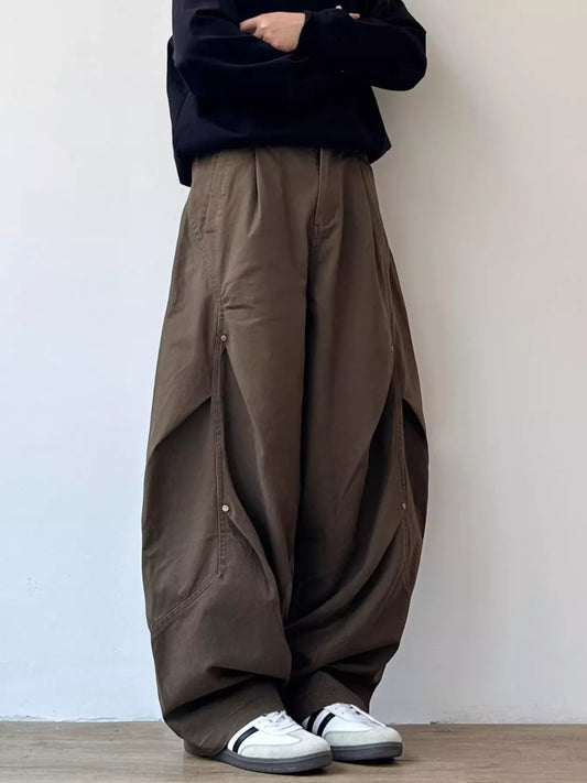 Brown loose-fit cargo pants with large side flap pockets and relaxed drape